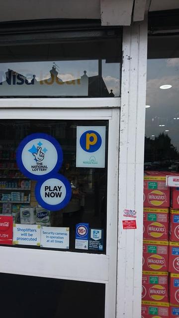 a shop door with a sign showing a yellow p in a blue circle