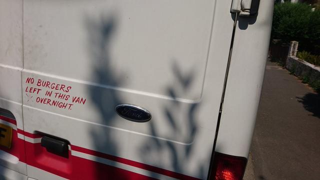 the rear door of a Ford Transit Van with the text "no burgers left in this van overnight"