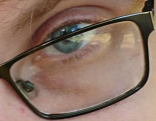 an eye behind a spectacle lens