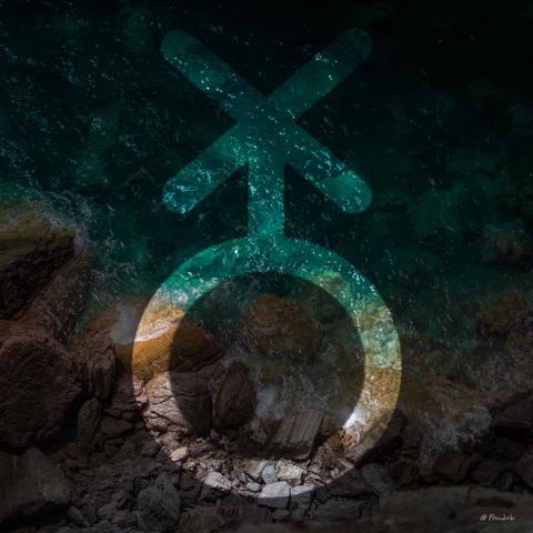 The nonbinary symbol over a picture of ocean waves crashing against rocks. The view in the picture is from above.