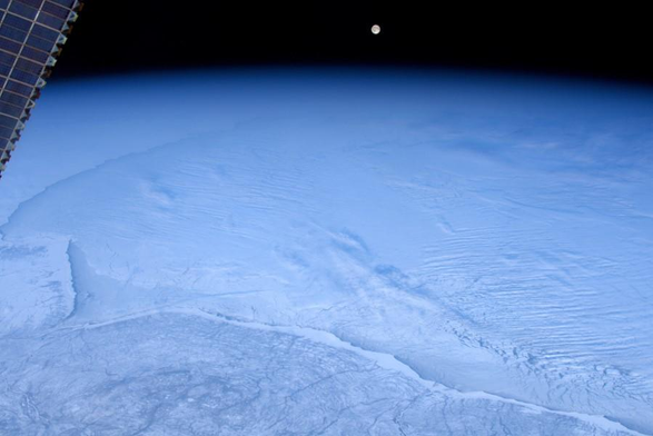 Paysage enneigé avec lever de Lune photographié en décembre 2019 depuis la station spatiale internationale par Luca Parmitano, astronaute de l'ESA.
