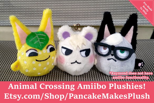 Three Animal Crossing Amiibo plushies. On the left is a yellow cat with white spots and a green leaf on her head named Tangy. In the middle is Marshall, a creme colored squirrel with blushy cheeks. On the right is Raymond, a gray cat with black ears and black glasses. The plushies are little palm sized round blob versions of the villagers.