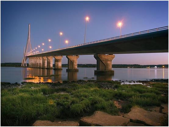 Photographie depuis la rive du viaduc nord du pont de Normandie au coucher de soleil