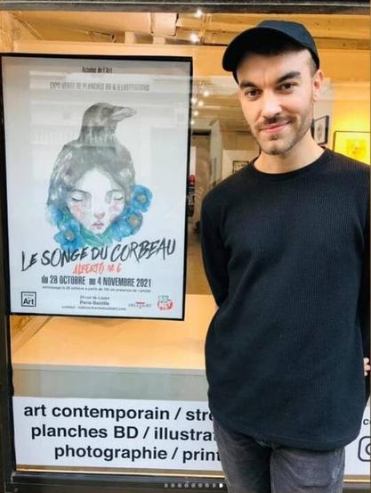 Photo d'Alberto MC devant la vitrine de la gallerie avec l'affiche de l'exposition.