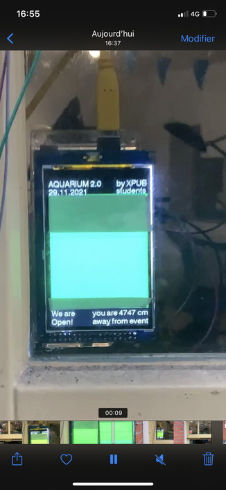 Screenshot of a phone interface displaying a closeup photo of an element of the window installation. It's a small LCD display with a sensor measuring how far in centimeters one is away from the event.