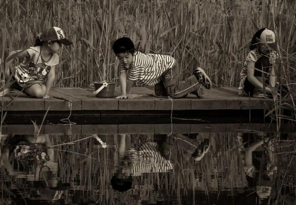 Kids playing at the edge of some water