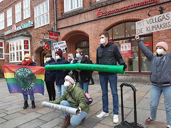 Protestaktion mit einem grünen Rohr: "Außen grün, innen dreckig", Plakat "Vollgas in die Klimakrise