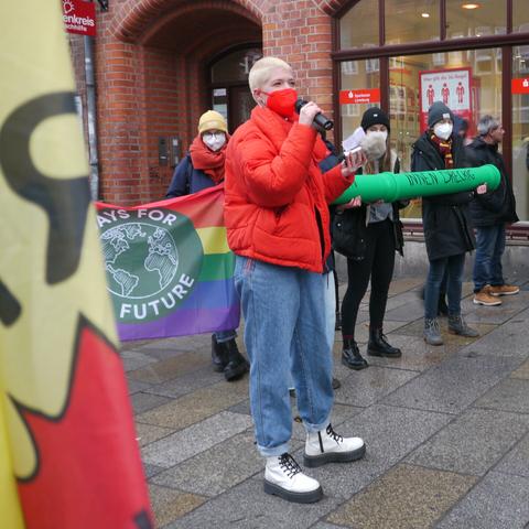 Redner*in mit rotem Oberteil