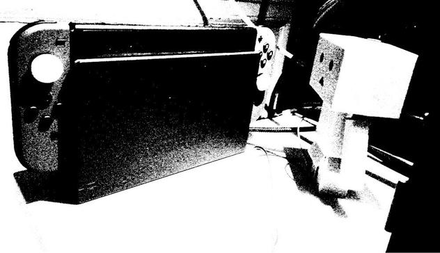 A black and white photo of a Danbo looking at a Nintendo Switch.