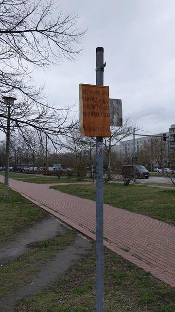 An einem Pfosten sieht man die Reste einer hölzernen Gedenktafeln.. Die Flanken der Platten sind mit massiver Gewalt abgeschlagen worden