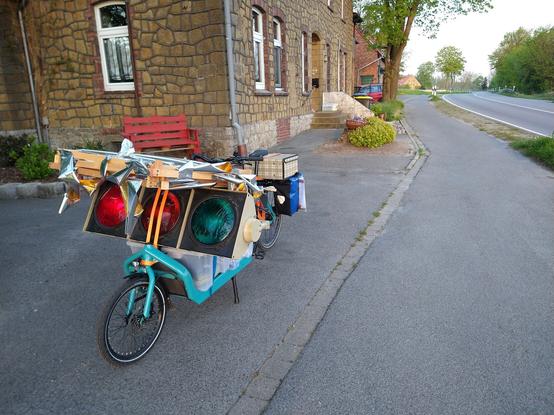 Voll bepacktes Lastenrad mit Ampel und zerlegten Glitzerwürfeln.