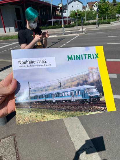 Außenaufnahme, Minitrix Neuheiten 2022 Katalog mit Blauling-Steuerwagen auf dem Cover wird ins Bild gehalten