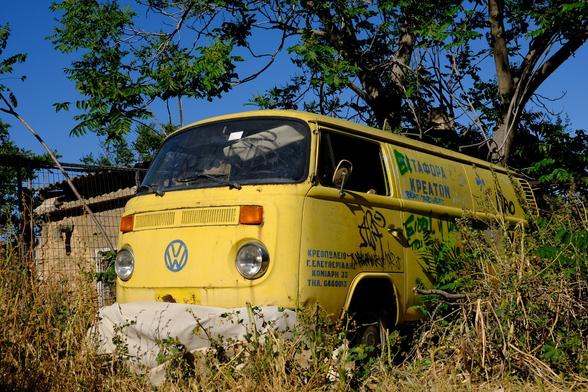 A rusty old yellow Volkswagen T2 transporter.