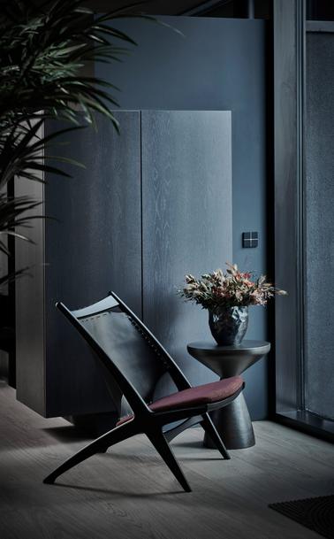 Black Krysset chair with a burgundy seat cushion in a dark room