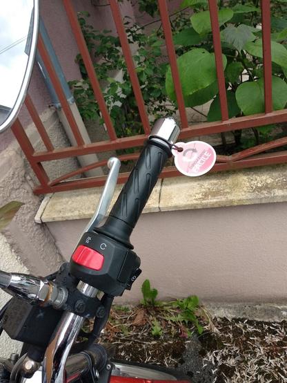 Étiquette "Enroulement facile" sur la poignée d'accélération d'une moto.