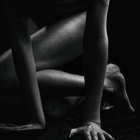 !B

The black and white photo shows a partial section of a nude photo. You can see supporting hands, as well as the legs, feet and arms of the person.