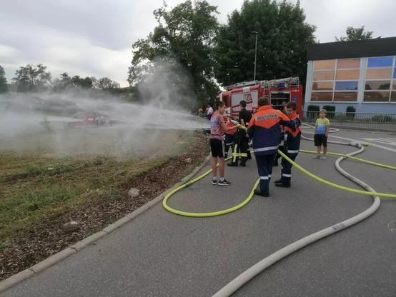 Jugendfeuerwehr gießt eine große Wiese.