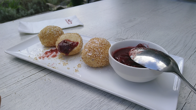 Die 3 Topfenknödel von vorhin, der mittlere ist nun halbiert und mit Zwetschgenröster benetzt.