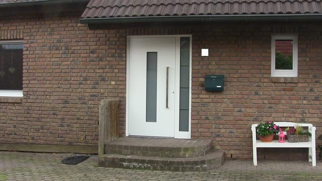 Verklinkerte Hausfront mit weißer Aluhaustür