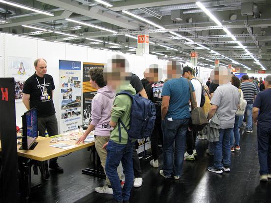 Auf den Bild ist ein Mitglied der LUG Nürnberg im Gespräch mit einigen Jugendlichen an unserem Stand zu sehen. Des Weiteren noch viele Messebesucher in der Nähe des Standes.