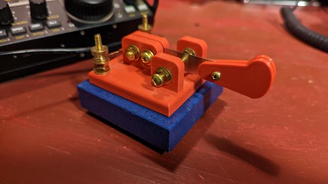 A 3D printed side-swiper morse code key on a marble base.