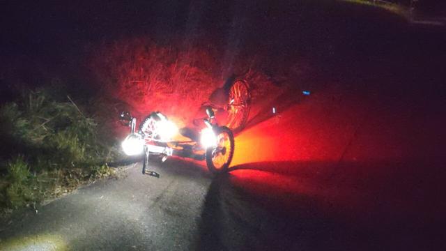 KMX X-Class Trike von schräg vorne bei Nacht. Knog Plus Akku-Leuchten in rot und nach hinten weisend an der Lenkerstange und in Stofflaschen der Sitzlehne, dazu weiße, nach vorne weisende Knog Plus auch wieder an der Lenkstange, zusätzlich noch eine hellere Leyzne Frontleuchte am Tretlager.