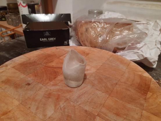 Half-melted vodka shot-glass, standing on a cutting board in an apartment prepared for renovation.