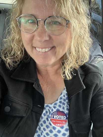 Smiling middle aged blonde sporting stunning “I voted” sticker