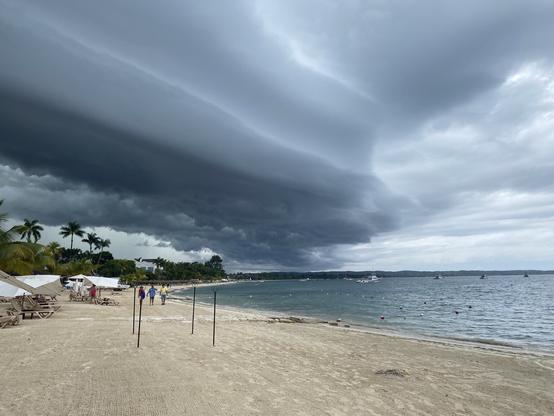 A thick stack of storm clouds rolling off the land toward the Caribbean shoreline. Reminds me of the edge of a stack of snow after I’ve sunk my shovel in and pulled it away.