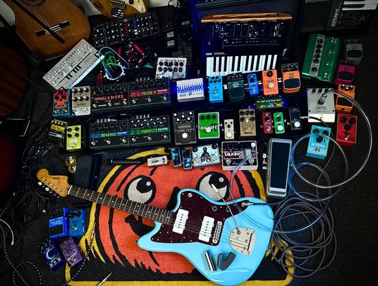 an absurd array of guitar pedals and synthesizers and cables that are very hard to keep track of