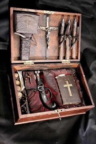 An antique vampire hunting kit with Bible crucifix stakes and holy water.