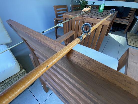 A very old handmade fishing rod made from a yellow fiberglass blank.