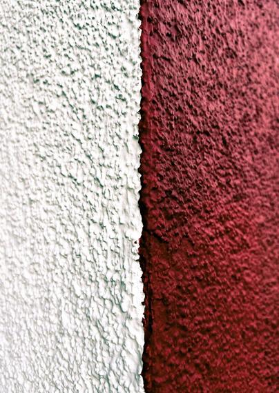 Ecke einer Fassade mit rechts tiefroter und links weißer Farbe