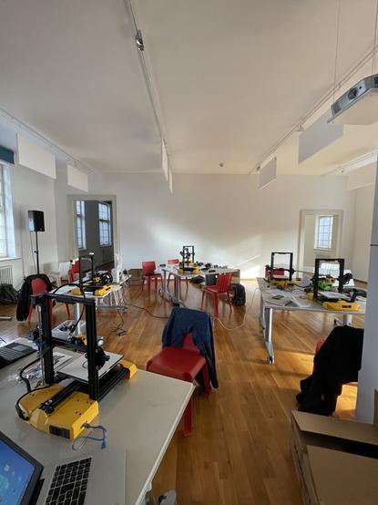 Vetanstaltungsraum in dem mehrere gleiche 3D Drucker stehen.