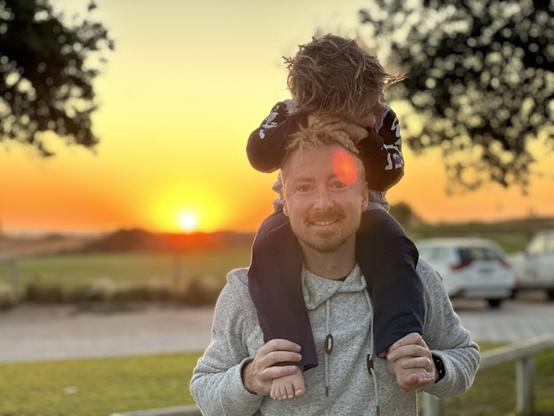 Little Noah-Otis gives his dad, Jarrod, a tired cuddle while having a shoulder ride as the sun sets over Ningaloo Reef, Coral Bay, Western Australia.