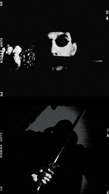 Two frames of black and white (square format film) one above the other.  Both are very high contrast to the point of looking like cartoons.  The top one shows a person wearing sunglasses and hat. the left side of their face completely in shadow.  To the left they are holding up a sword with an ornate hilt, the blade is horizontal and completely dark, hiding their mouth.

The lower picture is a person from behind, waist height, and in silhouette. The hat shape is more visible and is an old 20's style fedora.  At the bottom of the pics the knuckles of a hand are bright and holding the same sword.  The back edge of which is slightly brighter so you can see that it is held upside down, behind the back.
