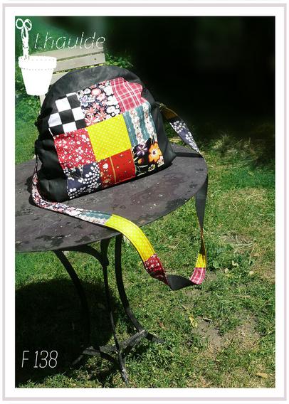 sac en toile noire décoré de carrés de tissus de différentes couleurs et motifs