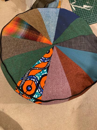 Over head view of the circular top with 12 pieces of different fabric triangles arranged to make a circular top