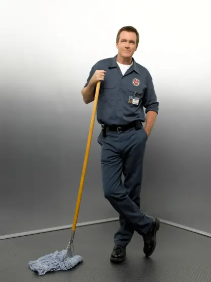 Der Hausmeister aus "Scrubs" in lässiger Pose mit einem Wischmop in der Hand