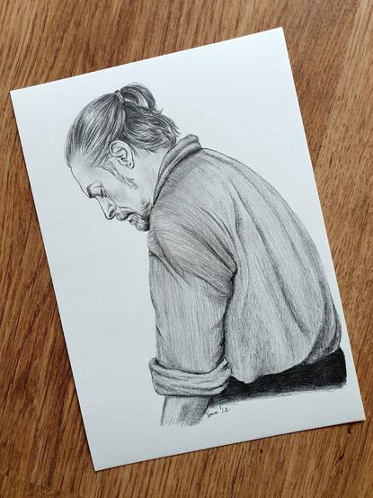 A drawing of a pirate captain sitting down in a resigned way, looking down.