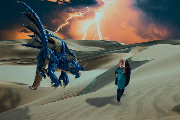 a blue dragon hovers in the desert air above a young child using a cloak to shield her face from the wind.