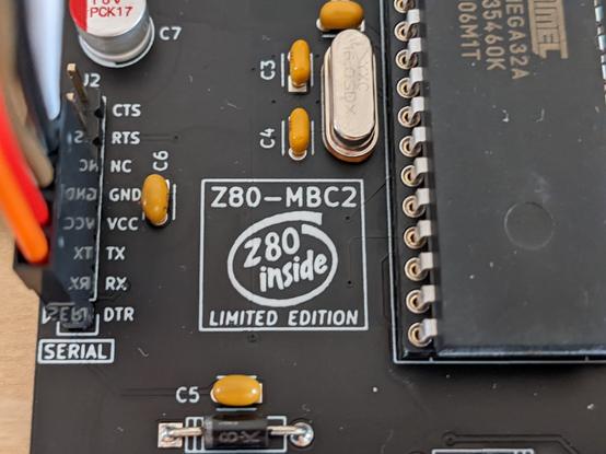 Closeup view from above of a black printed circuit board with a black chip. The board has a white logo similar to the "Intel inside" logo, but with the word Intel replaced by "Z80". The label "Z80-MBC2" is above the logo, the label "LIMITED EDITION" below.