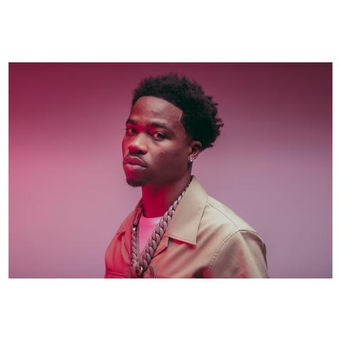 Portrait of rapper Roddy Ricch wearing a beige suit and thick necklace chain.
