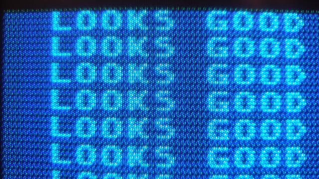 Closeup into a CRT screen showing text "LOOKS GOOD".