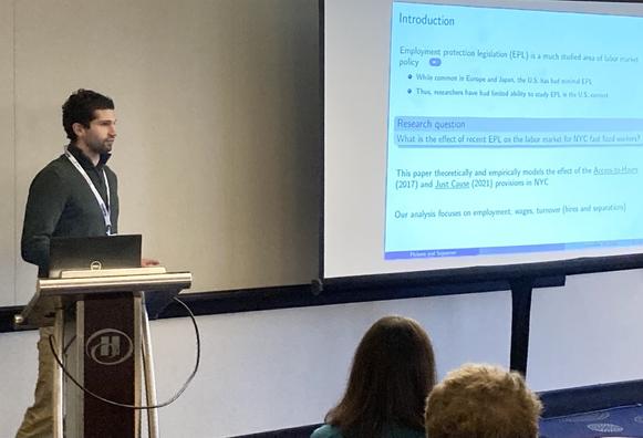 Joey Pickens at lectern with research slide