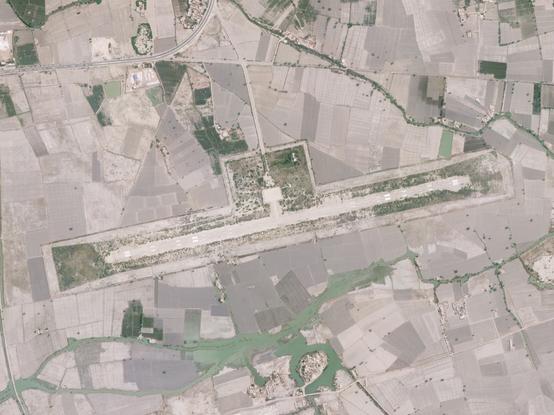 Airstrip before flooding, surrounded by fields.