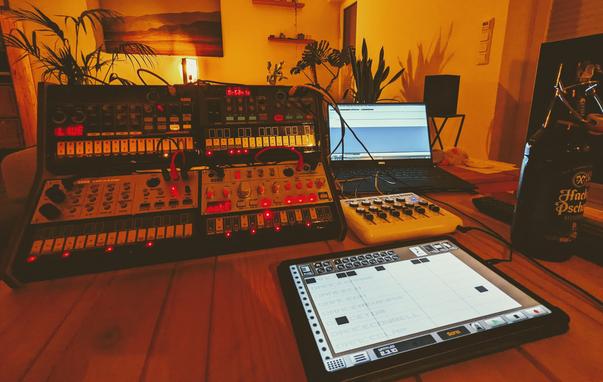 Bunch of synthesisers and electronic devices on a table.