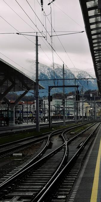Blick vom Salzburger Bahnhof auf schneebedeckte Berge.