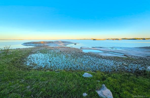 Merimaisema, tyyntä, auringonlaskun värejä taivaanrannalla.