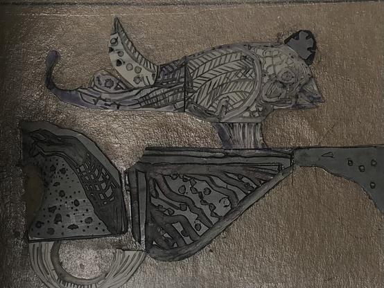 Lino cut plate for a relief print of a bird with a crown standing on a decorative fragmented wall.